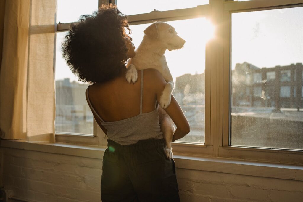 Photo by Samson Katt: https://www.pexels.com/photo/black-woman-holding-dog-near-window-5256719/